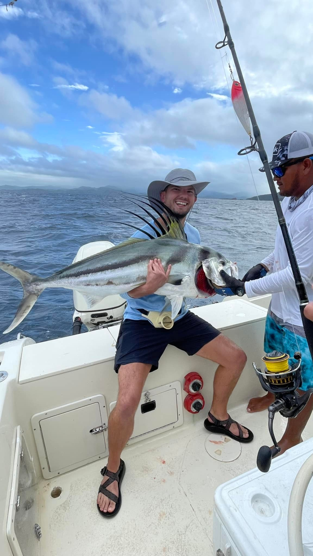 Guest holding a rooster fish trophy